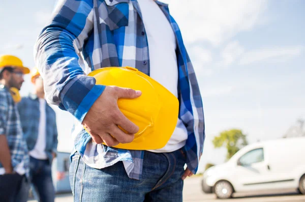 Close up de construtor segurando hardhat no edifício — Fotografia de Stock