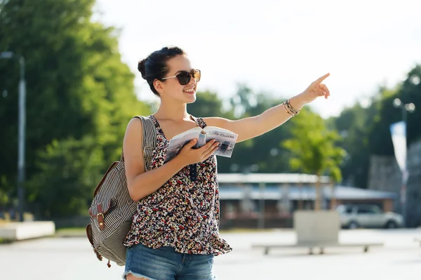 Happy teenage girl with guidebook and backpack — Stock fotografie