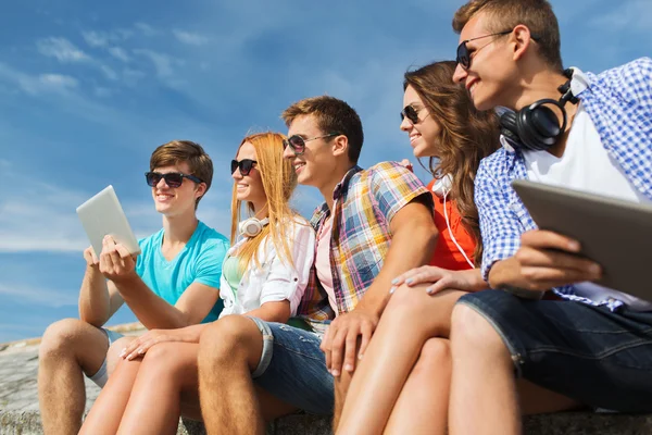 Группа улыбающихся друзей с планшетным ПК на открытом воздухе — стоковое фото