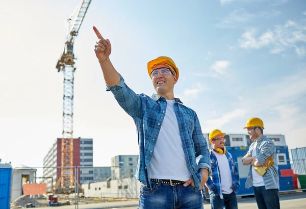 Construtores apontando dedo de lado na construção — Fotografia de Stock