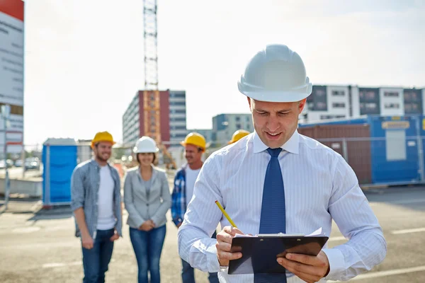 Zufriedene Bauarbeiter und Architekten auf der Baustelle — Stockfoto