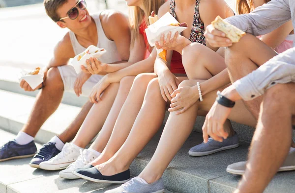 Amigos felices comiendo comida rápida para llevar en la ciudad — Foto de Stock