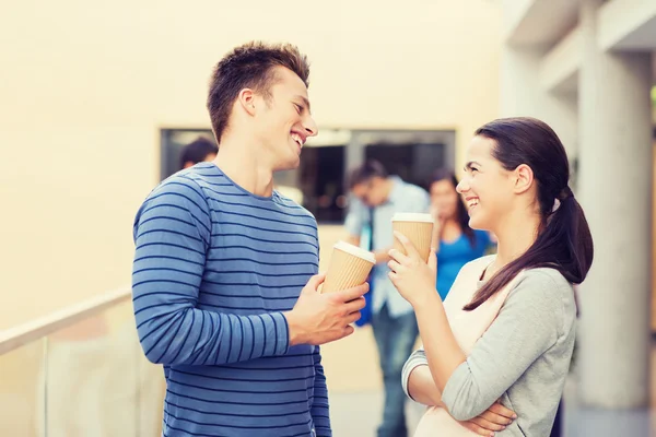 Group of smiling students with paper coffee cups — Stock Photo, Image