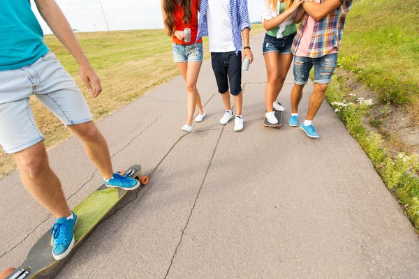 Close up of friends with longboards and drinks — Stock Photo, Image