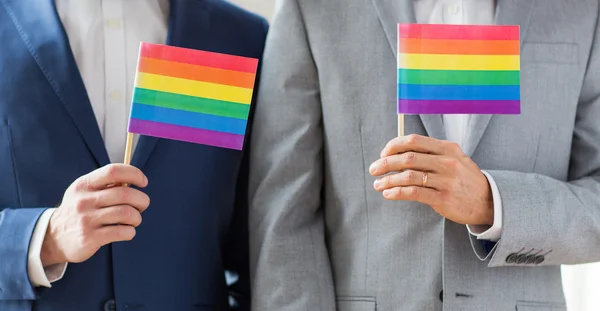 Close up de masculino gay casal segurando arco-íris bandeiras — Fotografia de Stock