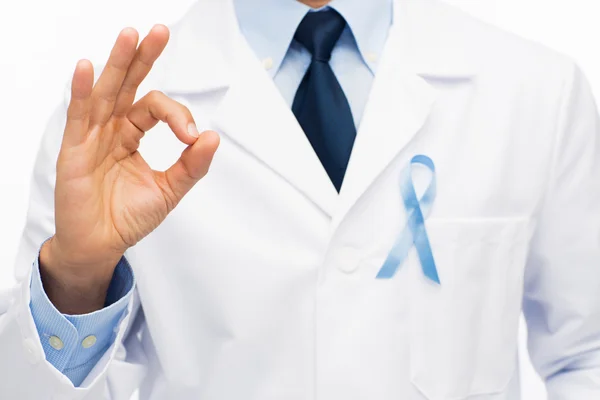 Happy doctor with prostate cancer awareness ribbon — Stock Photo, Image