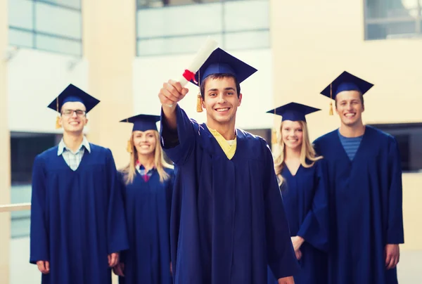 Grupp leende studenter i mortarboards — Stockfoto