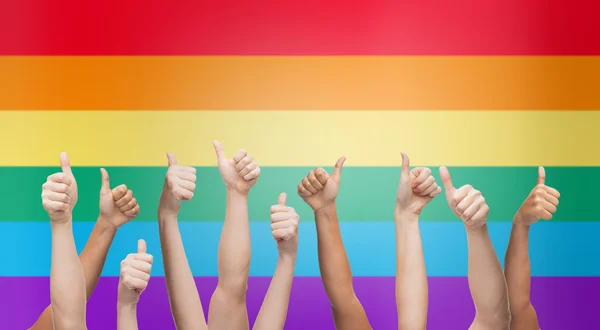 Hands showing thumbs up over rainbow background — Stok fotoğraf