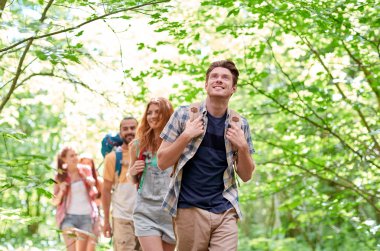 group of smiling friends with backpacks hiking clipart