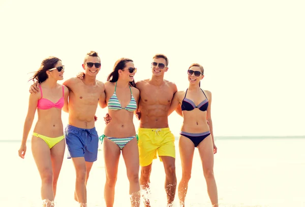 Amigos sorridentes em óculos de sol na praia de verão — Fotografia de Stock