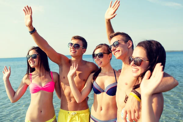 Lächelnde Freunde mit Sonnenbrille am Sommerstrand — Stockfoto