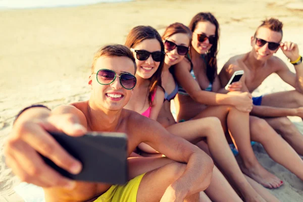 Amis avec smartphones sur la plage — Photo