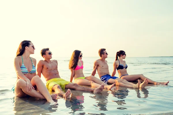 Lächelnde Freunde mit Sonnenbrille am Sommerstrand — Stockfoto