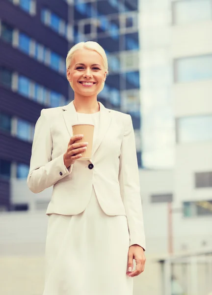 Mujer de negocios sonriente con taza de papel al aire libre — Foto de Stock