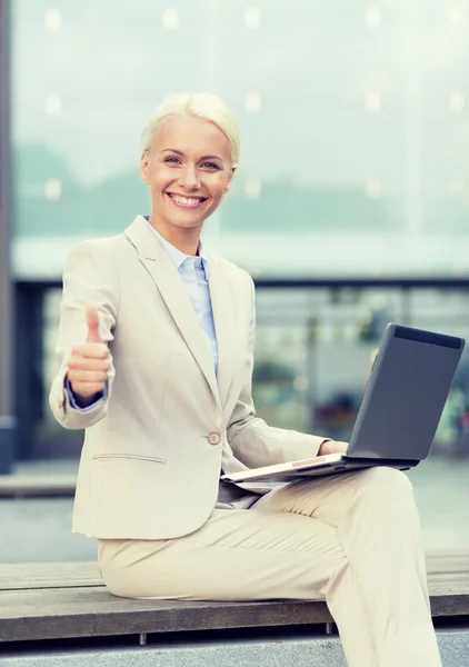 Sonriente mujer de negocios trabajando con el ordenador portátil al aire libre —  Fotos de Stock