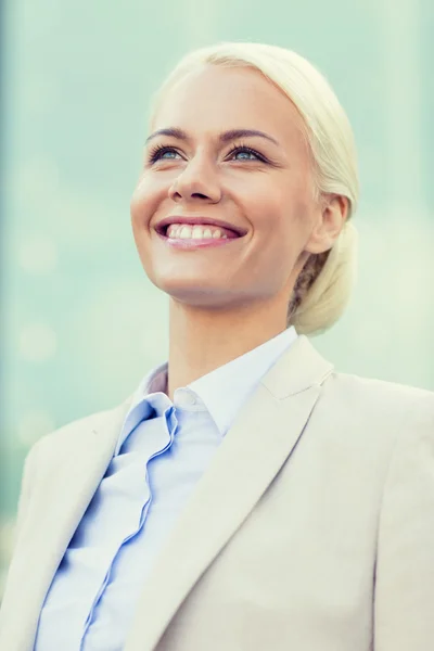 Jeune femme d'affaires souriante sur immeuble de bureaux — Photo