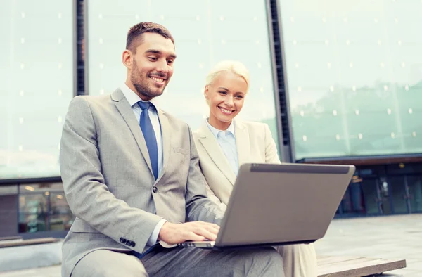 Lächelnde Geschäftsleute mit Laptop draußen — Stockfoto