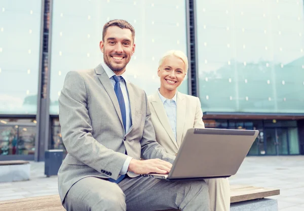 Sonrientes empresarios con portátil al aire libre —  Fotos de Stock