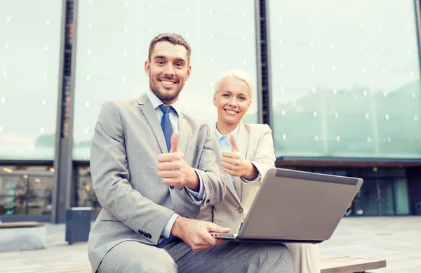 Sonrientes empresarios con portátil al aire libre — Foto de Stock