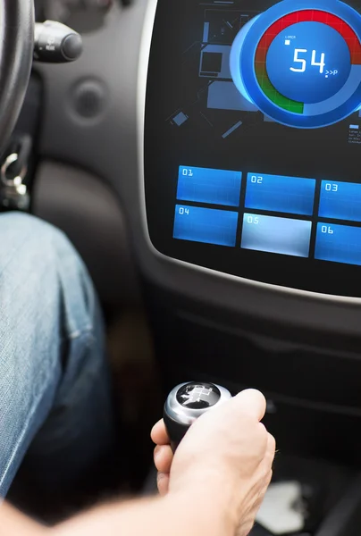 Hand on car gearshift and screen with volume level — 图库照片