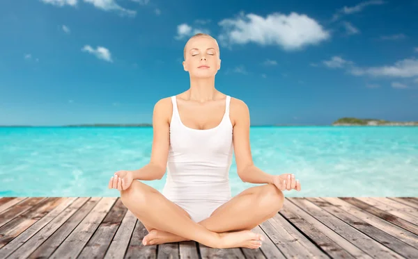Женщина медитирует в позе лотоса йоги — стоковое фото