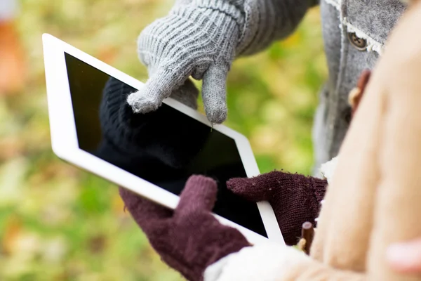 Mãos de casal em luvas com tablet pc ao ar livre — Fotografia de Stock