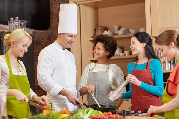 Gelukkig vrouwen en chef kok koken in de keuken — Stockfoto