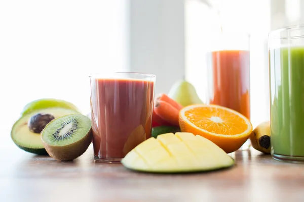 鲜榨果汁玻璃和桌上的水果的特写 — 图库照片