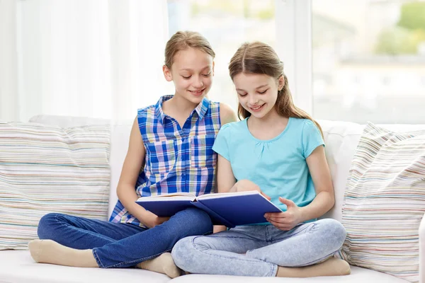 Duas meninas felizes lendo livro em casa — Fotografia de Stock