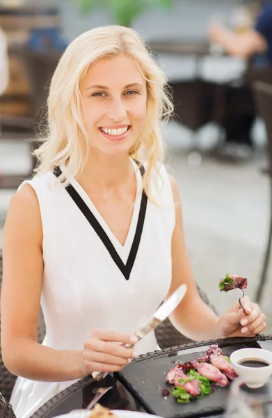 Šťastná žena jíst večeři na terase restaurace — Stock fotografie