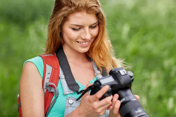 Mulher feliz com mochila e câmera ao ar livre — Fotografia de Stock