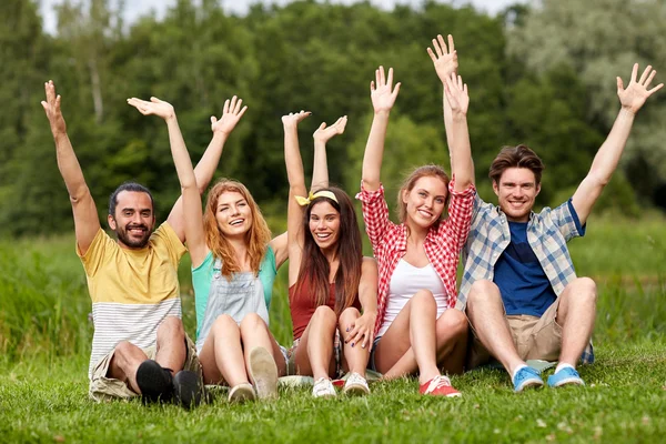 Grupo de amigos sonrientes agitando las manos al aire libre — Foto de Stock