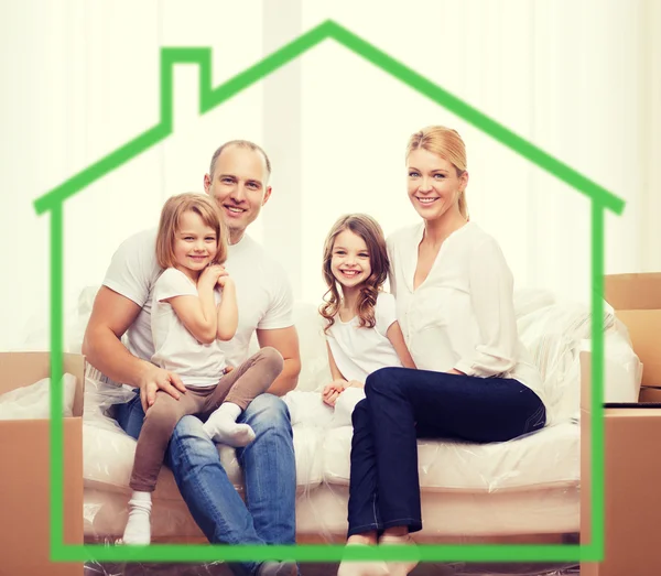 Smiling parents and two little girls at new home — Stock Photo, Image