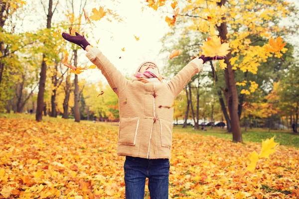 Ragazzina sorridente con foglie autunnali nel parco — Foto Stock