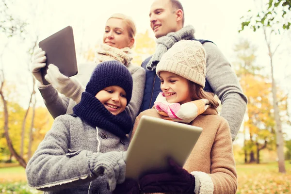 Met de tablet pc in de herfst park en gelukkige familie — Stockfoto