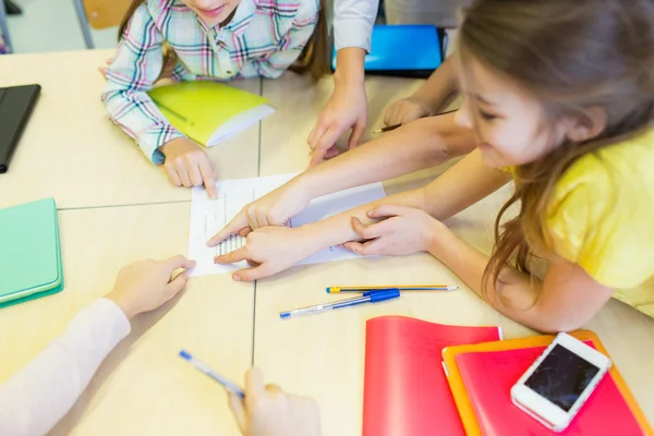 Group of school kids pointing fingers to test — Stockfoto