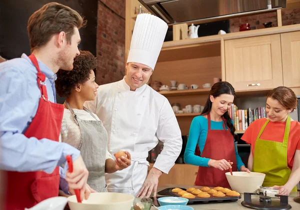 Glada vänner och kocken laga bakning i köket — Stockfoto