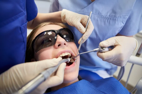 Dentistas mulheres que tratam os dentes da menina paciente — Fotografia de Stock