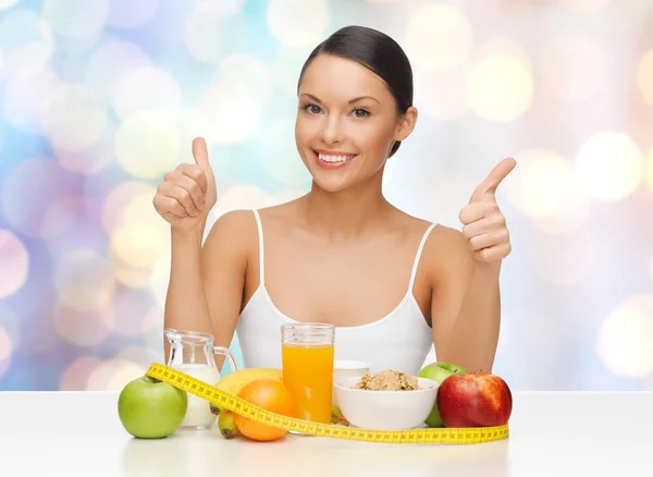 Happy woman with healthy food showing thumbs up — Zdjęcie stockowe