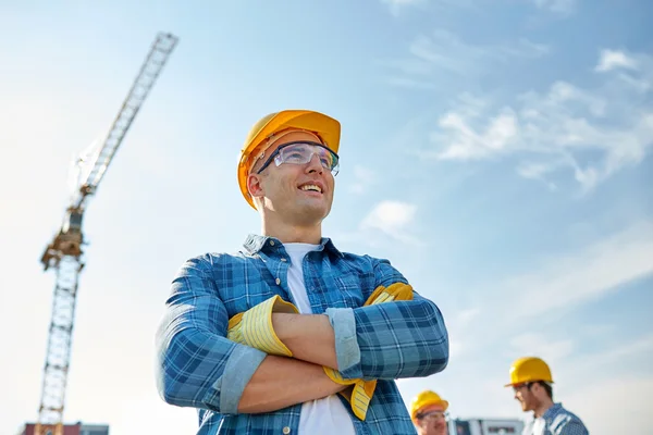 Gruppo di costruttori sorridenti in hardhats all'aperto — Foto Stock