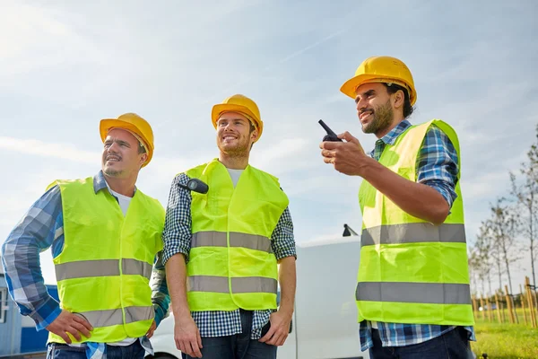 Mellények, walkie-talkie-boldog férfi építők — Stock Fotó