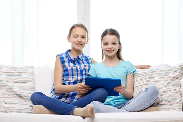 Chicas felices con la tableta PC sentado en el sofá en casa —  Fotos de Stock