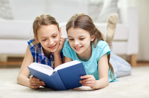 Duas meninas felizes lendo livro em casa — Fotografia de Stock