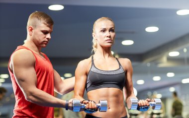 young couple with dumbbells flexing muscles in gym clipart