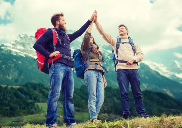 Grupo de amigos sonrientes con mochilas senderismo — Foto de Stock