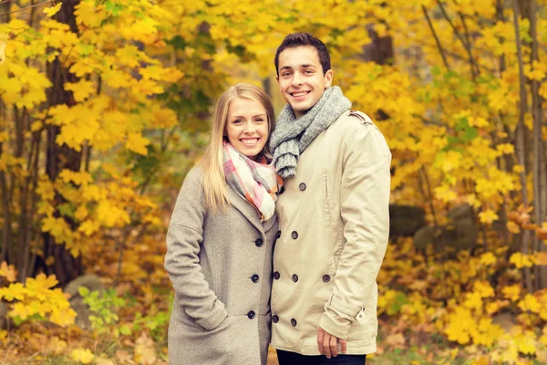 Χαμογελαστό ζευγάρι αγκαλιάζει στο πάρκο φθινόπωρο — Φωτογραφία Αρχείου
