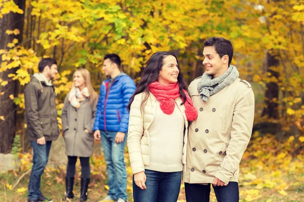 Grupo de hombres y mujeres sonrientes en el parque de otoño —  Fotos de Stock