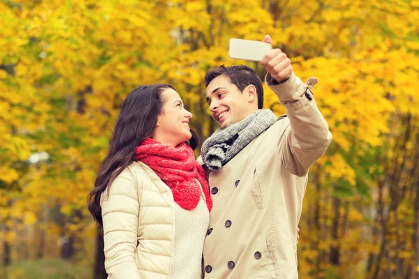 Usmívající se pár objímání v podzimním parku — Stock fotografie