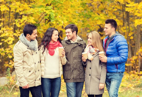 Group of smiling friend with coffee cups in park — Stock Photo, Image