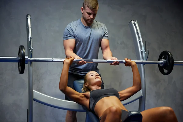 Spor salonunda halterli kadın ve erkek kaslarını esnetiyor. — Stok fotoğraf